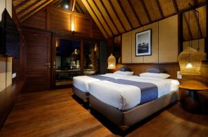 a bedroom with two large beds in a room at Bingin Lodge Uluwatu in Uluwatu