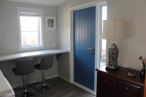 a room with a blue door and a desk and chairs at Blue Skies Guest Accommodation in Queenstown