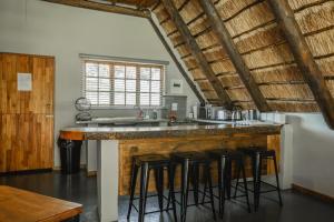 a kitchen with a counter with bar stools at Penwarn Farm in Drakensberg Garden +168 photos