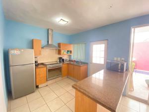 a kitchen with a refrigerator and a counter top at Tropical Home in excellent location just 10 min from Nuevo Vallarta Beach in Mezcales