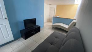 a living room with a couch and a television at Tropical Home in excellent location just 10 min from Nuevo Vallarta Beach in Mezcales