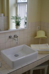 a white sink in a bathroom with a mirror at Hotel Alte Landschule in Langballig