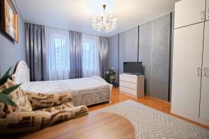 a bedroom with a bed and a television and a chandelier at Holiday and Travel Apartment in Brest