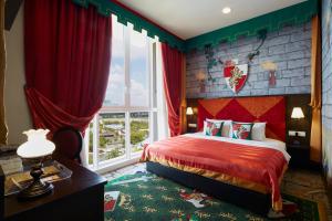 una camera da letto con un letto rosso e una finestra di Legoland Malaysia Hotel a Nusajaya