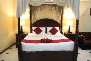 um quarto com uma cama grande com um arco vermelho em ORIENTAL CORNER HOTEL APARTMENTS LLC em Dubai