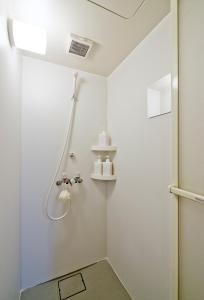 y baño con ducha y paredes blancas. en Lucy's House横浜中華街 House5 en Yokohama