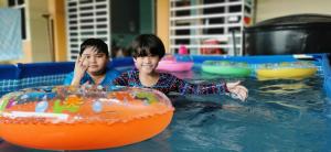 two young boys playing in a swimming pool at Teku Homestay Geting Tumpat Kelantan in Kampong Geting