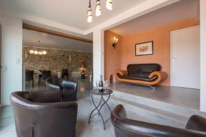a living room with leather chairs and a table at Maison de 5 chambres avec piscine privee terrasse amenagee et wifi a La Digne d'Aval in La Digne-dʼAval