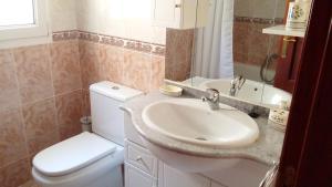 un bagno con un water bianco e un lavandino di Charming House in Aldea Real with terrace and fireplace a Aldea Real