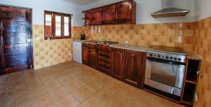 a kitchen with wooden cabinets and a stove top oven at Refined Villa near Catanhede with Private Pool in Cantanhede