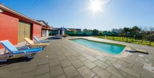 a swimming pool with lounge chairs next to a house at Refined Villa near Catanhede with Private Pool in Cantanhede