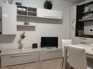 a living room with a tv on a white cabinet at Bilocale in corte a Boltiere (BG) in Boltiere