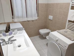 bagno con lavandino bianco e servizi igienici di Bilocale in corte a Boltiere (BG) a Boltiere