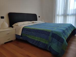 een slaapkamer met een bed met een blauw en groen dekbed bij Bilocale in corte a Boltiere (BG) in Boltiere