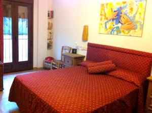 1 dormitorio con 1 cama con colcha roja en 5 bedrooms house with private pool furnished terrace and wifi at Zambra en Zambra