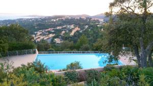 a large swimming pool with a view of a city at Appartement lumineux Roquebrune 45m² avec piscine partagée in Roquebrune-sur-Argens