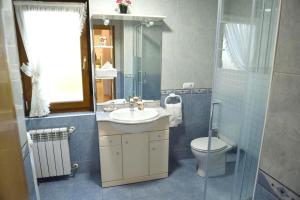 a bathroom with a sink and a toilet and a mirror at Cozy apartment in Mogro, 63 m² with private pool! in Mogro +46 photos