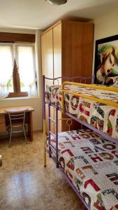 a bedroom with two bunk beds and a desk at Cozy apartment in Mogro, 63 m² with private pool! in Mogro