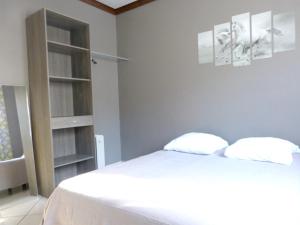 a bedroom with a white bed with two pillows at Maison de 2 chambres avec jardin clos a Cilaos in Cilaos