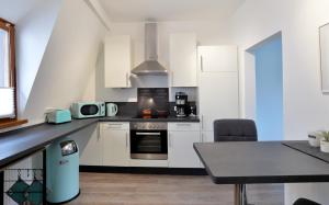 a kitchen with white cabinets and a counter top with a table at Ferienhaus Maja in Cochem