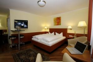 een slaapkamer met een bed en een laptop op een tafel bij Gästehaus Kral in Erlangen