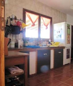 cocina con encimera y nevera blanca en One bedroom house with garden at Triquivijate, en Antigua