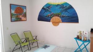 a room with two chairs and a table and a painting at Appartement moderne à Sainte-Anne 43 m² avec vue mer in Sainte-Anne +45 photos