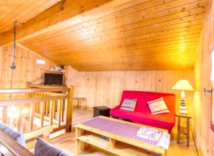 a living room with a red couch in a cabin at Chalet de 2 chambres avec terrasse amenagee et wifi a Saint Gervais les Bains a 3 km des pistes in Saint-Gervais-les-Bains