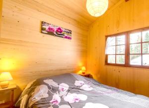 サン・ジェルヴェ・レ・バンにあるChalet de 2 chambres avec terrasse amenagee et wifi a Saint Gervais les Bains a 3 km des pistesの木造キャビン内のベッド1台が備わるベッドルーム1室を利用します。