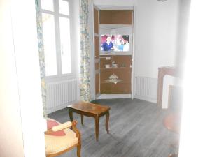 ein Wohnzimmer mit einem Tisch und einem TV in der Unterkunft Maison de 3 chambres avec jardin clos et wifi a Airvault in Airvault
