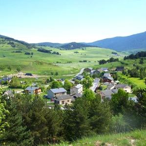 a small town in a green field with houses at Appartement de 2 chambres avec vue sur le lac et jardin clos a Fontrabiouse a 7 km des pistes in Fontrabiouse