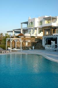 a large swimming pool in front of a house at Anthea Hotel in Tinos Town