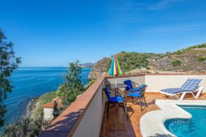 ネルハにある2 bedrooms house at Nerja 300 m away from the beach with sea view private pool and furnished terraceの海を望むバルコニー(テーブル、椅子付)