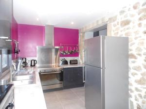 eine Küche mit einem Kühlschrank aus Edelstahl und lila Wänden in der Unterkunft Villa de 4 chambres avec piscine privee jacuzzi et jardin clos a Prades in Prades