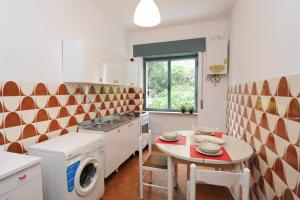a small kitchen with a table and a laundry machine at One bedroom apartement at Maiori 50 m away from the beach with furnished balcony and wifi in Maiori