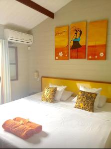 1 dormitorio con 1 cama blanca con pinturas en la pared en One bedroom house at Albion 100 m away from the beach with shared pool enclosed garden and wifi, en Albion