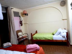 a bedroom with two beds and a chair at Maison de 2 chambres a Sainte Anne a 100 m de la plage avec vue sur la mer jardin clos et wifi in Sainte-Anne