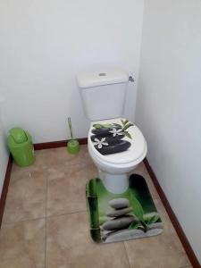 a bathroom with a toilet with a towel on the floor at Bungalow de 2 chambres avec piscine partagee jacuzzi et terrasse amenagee a Le Gosier a 5 km de la plage in Le Gosier