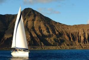 a sailboat in the water with a mountain in the background at Charming Boat in Funchal with Sea View in Funchal