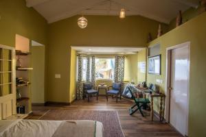 a bedroom with green walls and a table and chairs at Seclude Mussoorie in Mussoorie
