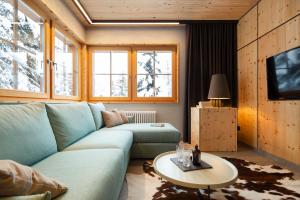 a living room with a blue couch and a table at Chalet Cirmolo in Livigno