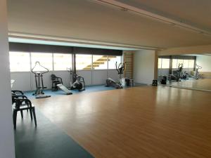 einen Fitnessraum mit Holzboden und Trainingsgeräten in der Unterkunft Bungalow confortable à Saint-Jean-de-Monts avec terrasse in Saint-Jean-de-Monts