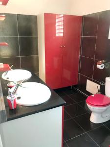 a bathroom with a red toilet and a sink at Maison de 2 chambres avec piscine partagee terrasse amenagee et wifi a Sainte Rose in Sainte-Rose