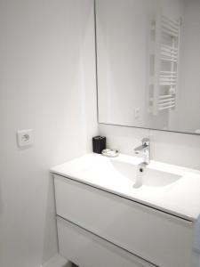 a white bathroom with a sink and a mirror at Appartement lumineux à Saint-Cyprien 45 m² vue mer in Saint-Cyprien