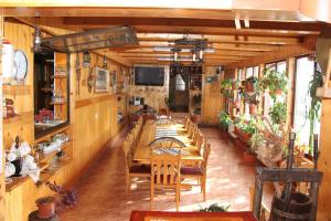 a dining room with a long table and a television at Pensiunea Casa Alex in Sadova
