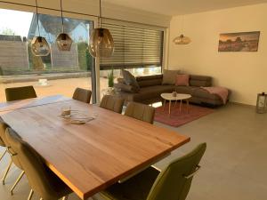 sala de estar con mesa de madera y sillas en Haus Steingrubenweg, en Mutlangen