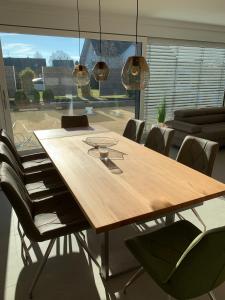 a dining room table with chairs and a large window at Haus Steingrubenweg in Mutlangen