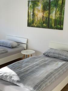 - une chambre avec 2 lits et un tableau mural dans l'établissement Haus Steingrubenweg, à Mutlangen