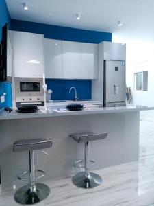 a kitchen with a counter with two bar stools at Modern apartment in Las Palmas 140 m² with air conditioning in Las Palmas de Gran Canaria