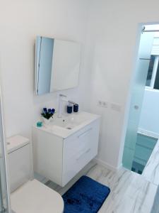 a white bathroom with a sink and a mirror at Modern apartment in Las Palmas 140 m² with air conditioning in Las Palmas de Gran Canaria +13 photos